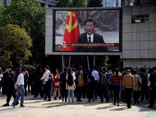 A TV screen shows a live news broadcast of Chinese President Xi Jinping introducing his Politburo Standing Committee, at the Nanjing pedestrian road in Shanghai
