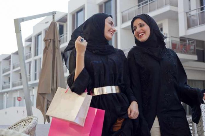 Young Emirati women walking with shopping bags.
