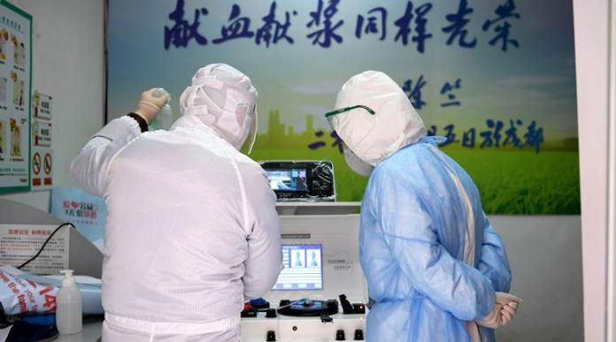Medical workers in protective suits inspect equipment at a blood donation room of the Renmin Hospital of Wuhan University