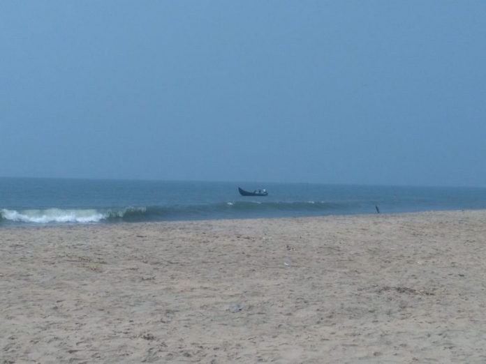 Malippuram beach, man fishing on small boat Malippuram beach, man fishing on small boat